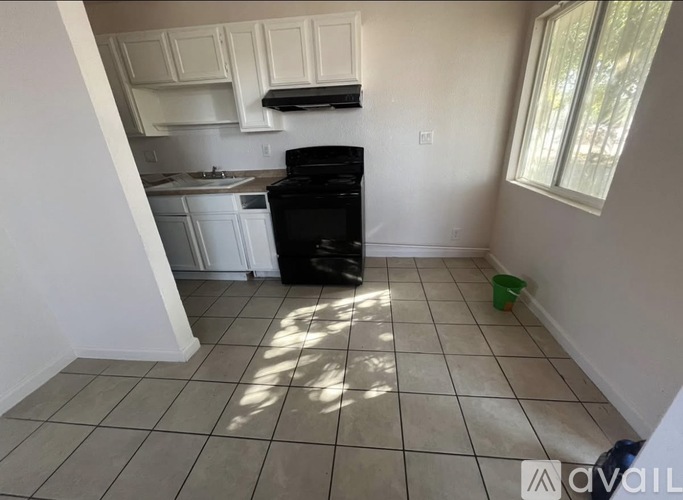 A kitchen with white cabinets and a black dishwasher.