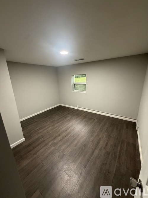 A room with wooden flooring and a window.