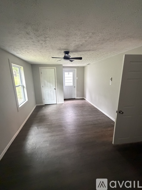 A room with a ceiling fan and two doors.