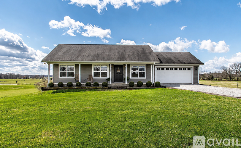 A house with a grey roof and a white garage door is available for purchase.