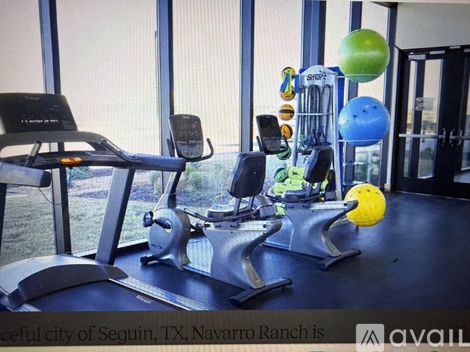 A gym with exercise equipment and a window in the background.