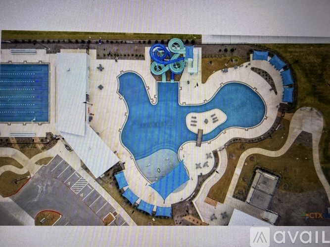 An aerial view of a resort with a large pool and a water slide.