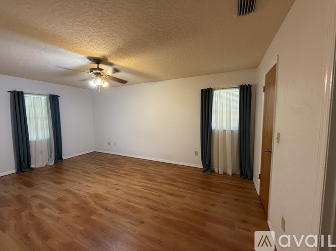 A room with wooden flooring and a ceiling fan.