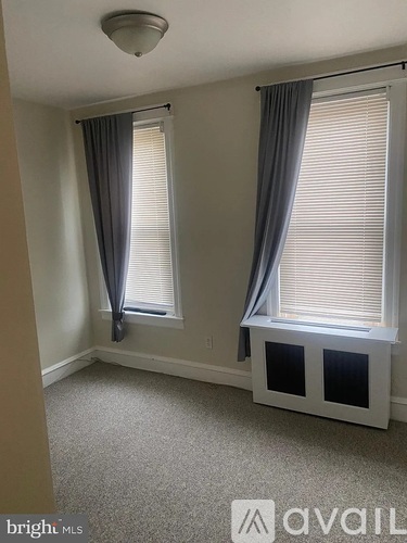 A room with two windows and a carpeted floor.