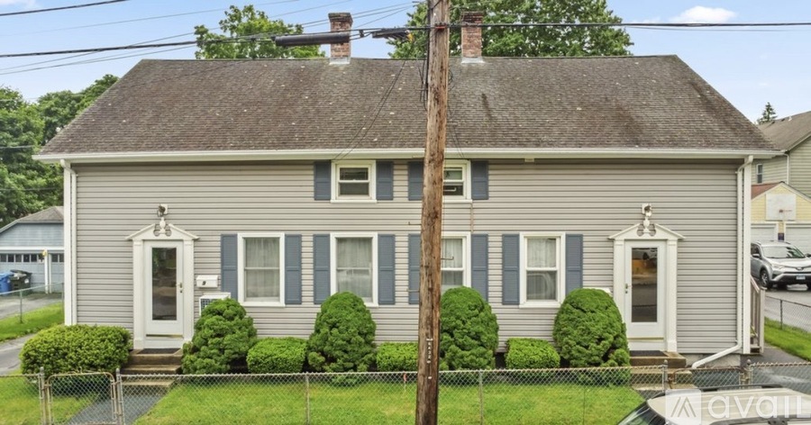 A two-story house with a grey exterior and white trim.