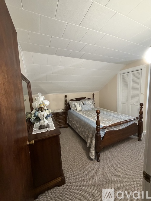 A bedroom with a bed, dresser, and nightstand.