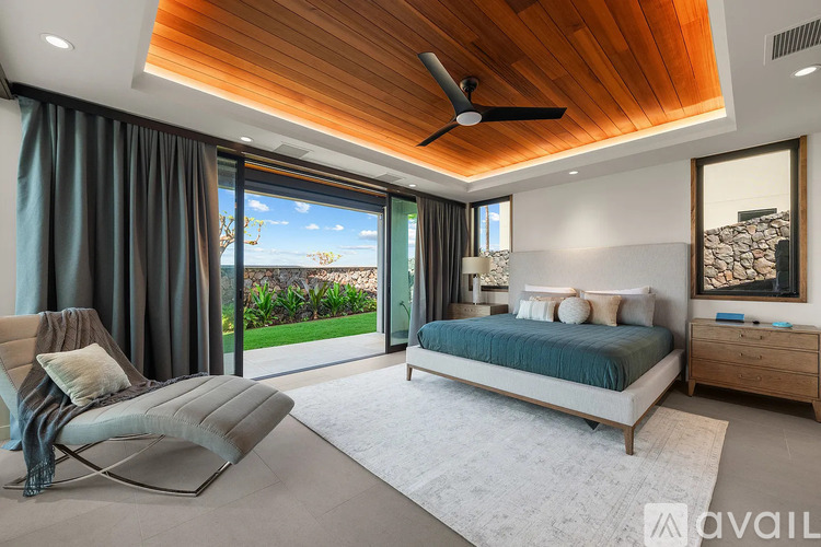A modern bedroom with a large bed and a ceiling fan.