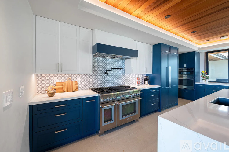 A kitchen with blue cabinets and a white countertop.