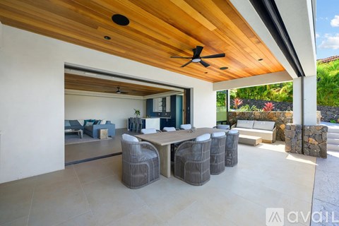 A modern outdoor living space with a wooden ceiling and a table set for four.