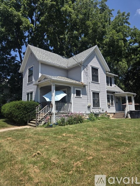 A two-story house with a porch and a covered staircase.