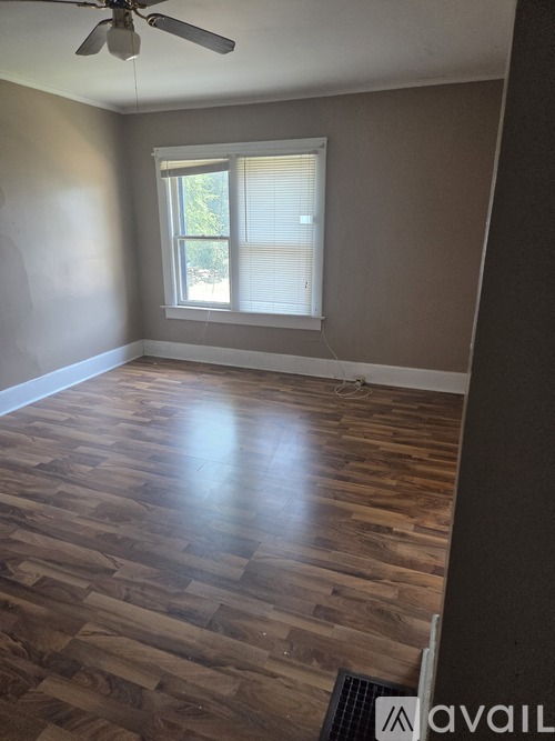A room with wooden flooring and a ceiling fan.