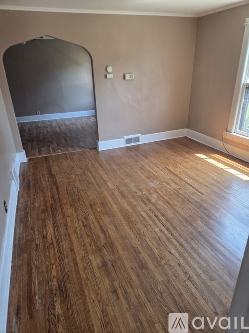 A room with wooden flooring and a window.