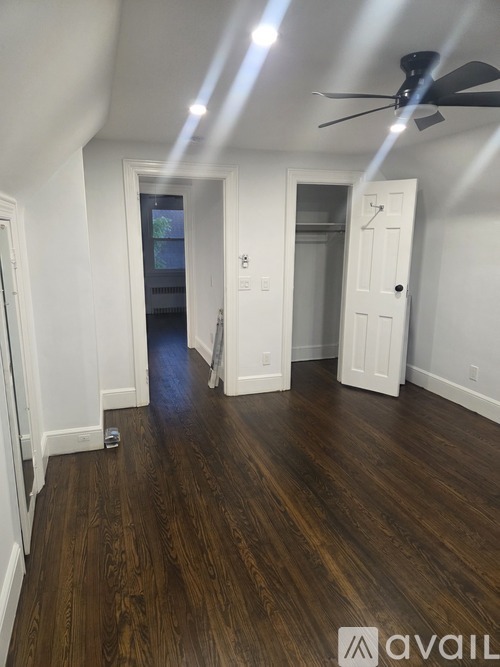 A room with wooden floors and a ceiling fan.
