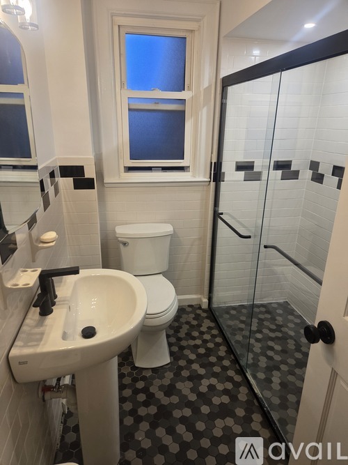 A bathroom with a toilet, sink, and shower.
