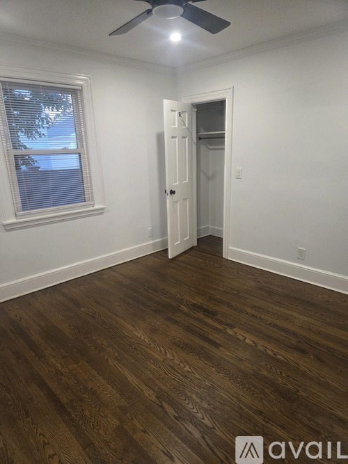 A room with a wooden floor and a ceiling fan.