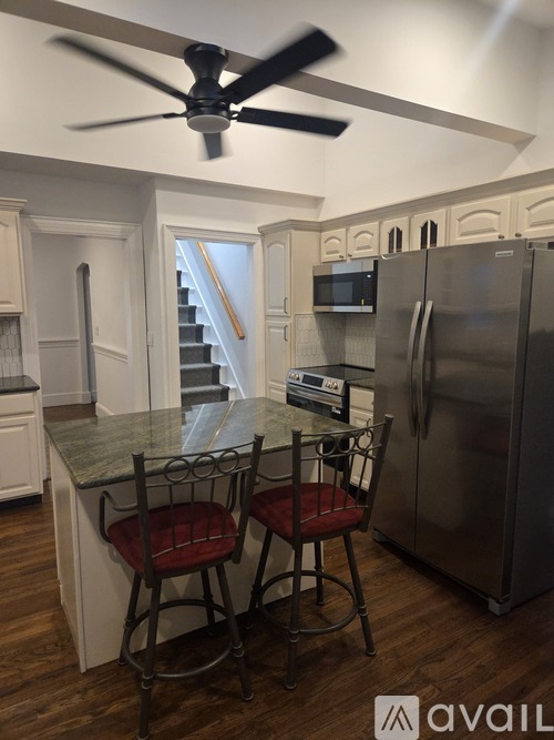 A kitchen with a table and two chairs.