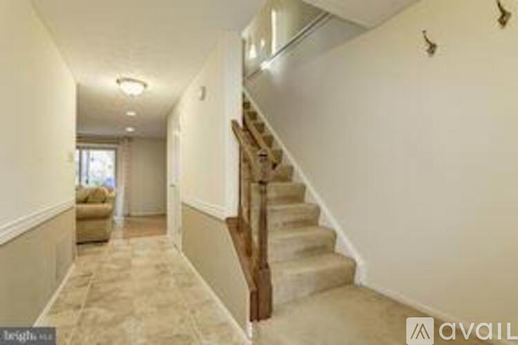 A hallway with a staircase and a window.