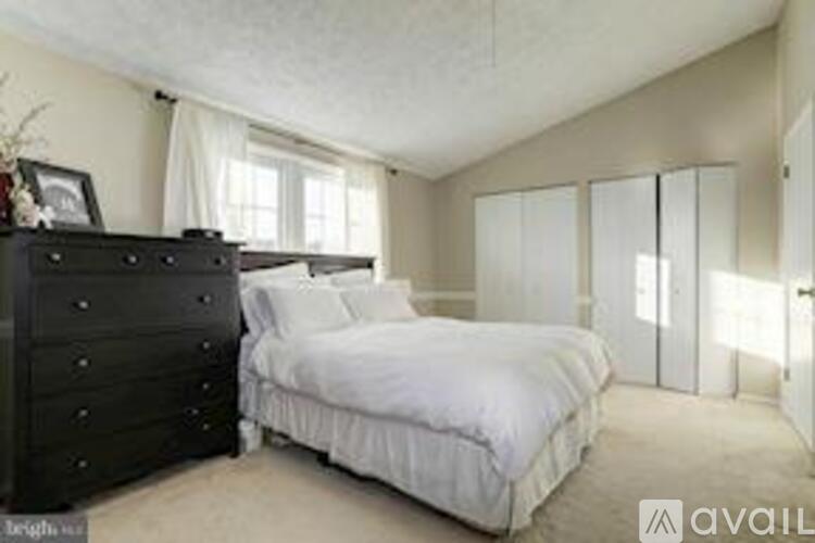 A bedroom with a large bed and a dresser.