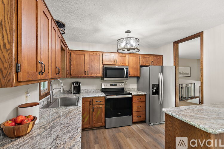 A kitchen with wooden cabinets and a granite countertop.