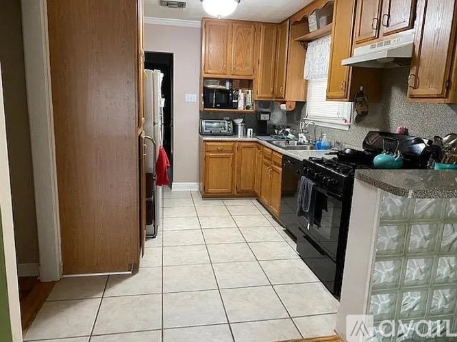 A kitchen with wooden cabinets and a black stove top oven.