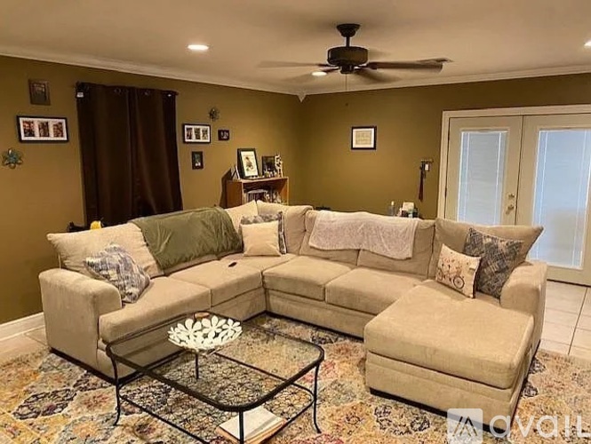 A living room with a beige sofa and a glass coffee table.