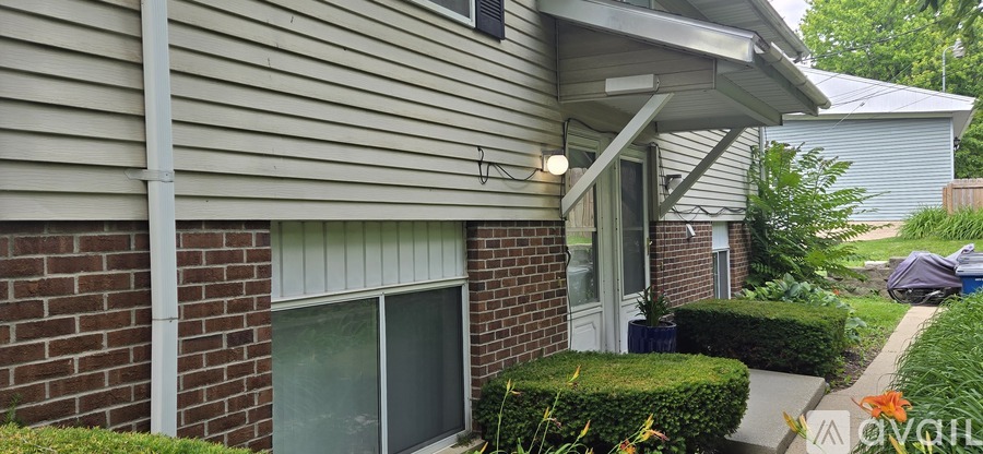 A house with a grey siding and a brick wall.