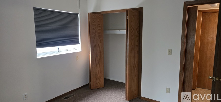 A room with a window, a closet, and a door.