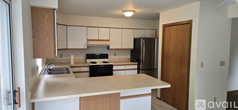 A kitchen with a black stove top oven and a black refrigerator.