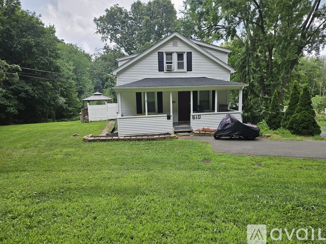 A two-story house with a porch and a covered entryway.