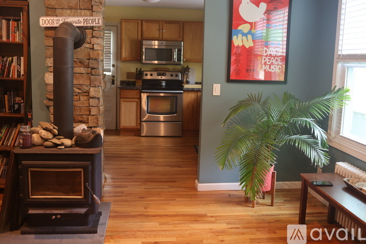 A living room with a wood stove and a painting on the wall.