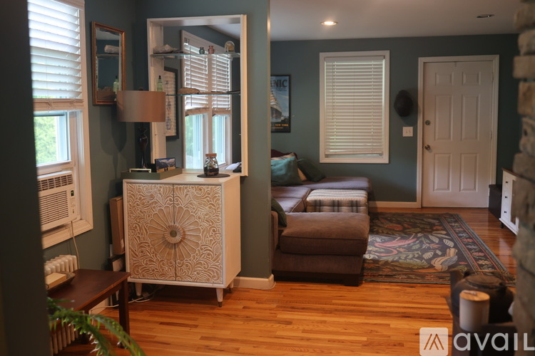 A room with a wooden floor and a cabinet with a design on it.