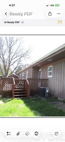 A house with a brown fence and a tree in the background.