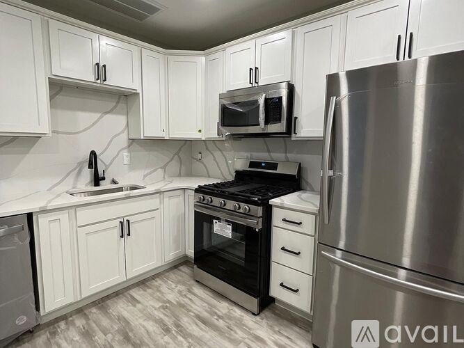 A kitchen with white cabinets and stainless steel appliances.
