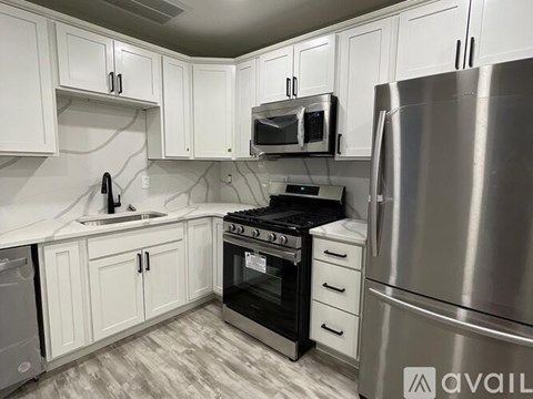 A kitchen with white cabinets and stainless steel appliances.