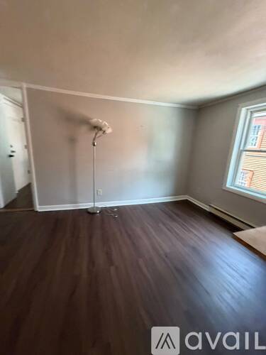 A room with wooden flooring and a window.