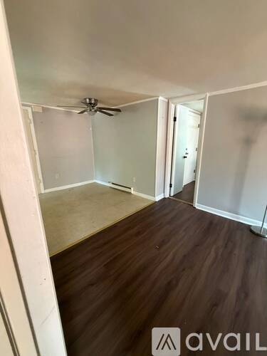 A room with wooden floors and a ceiling fan.