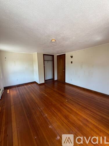 A room with wooden floors and a door.