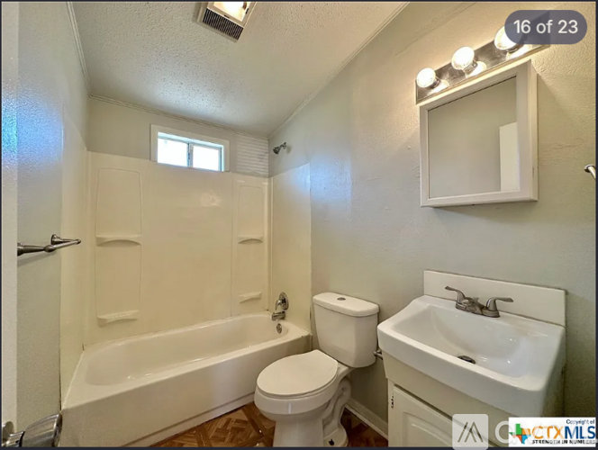 A white bathroom with a toilet, sink, and bathtub.