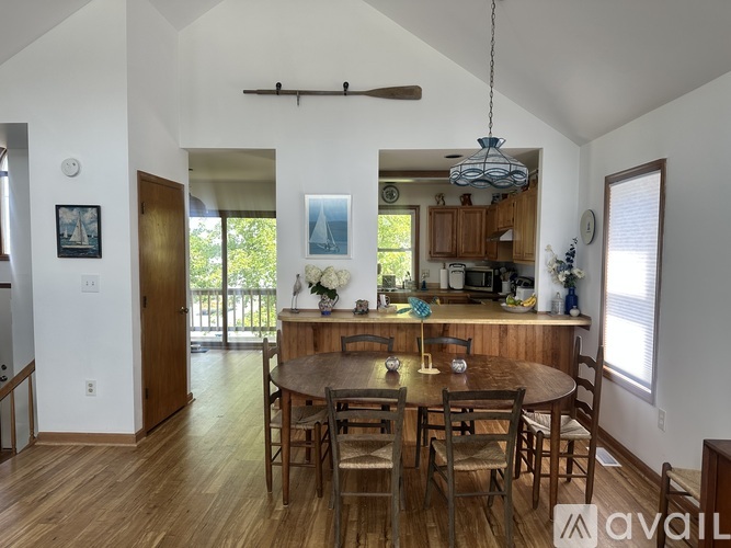 A dining room with a wooden table and chairs.