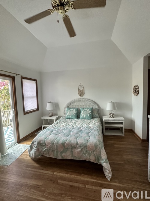 A bedroom with a bed, two nightstands, and a ceiling fan.