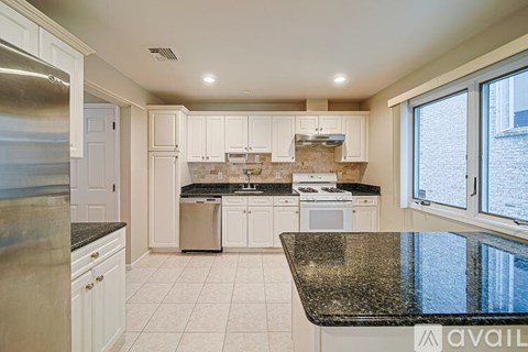 A kitchen with white cabinets and a granite countertop.