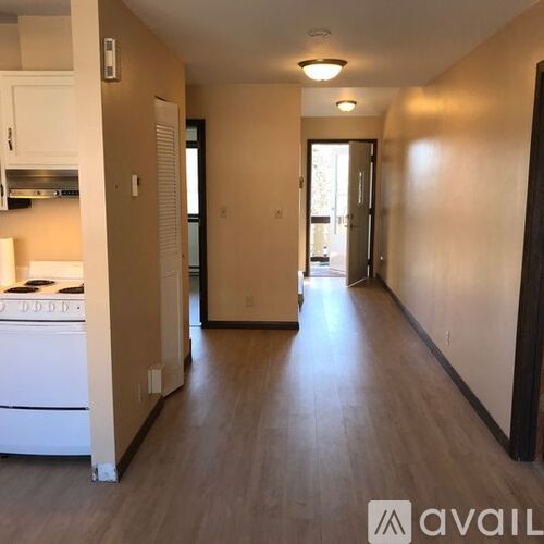 A long hallway with a kitchen area on the left side.