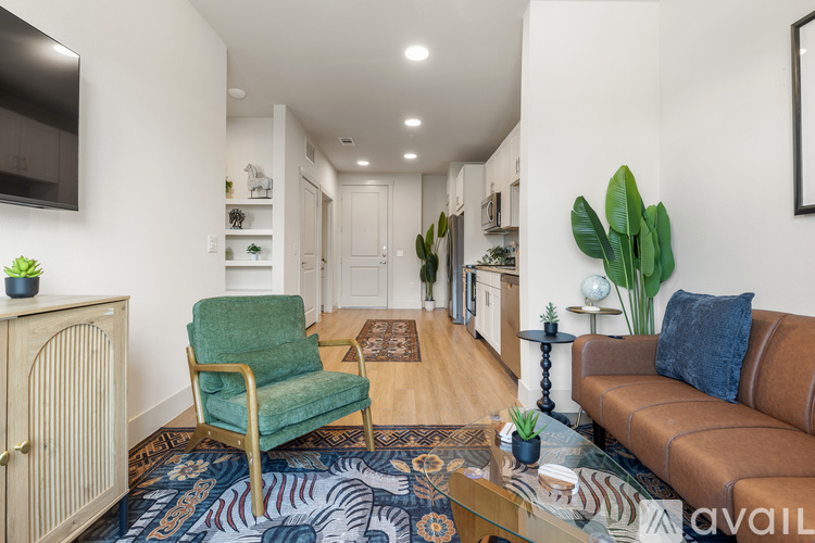 A living room with a green chair and a brown couch.