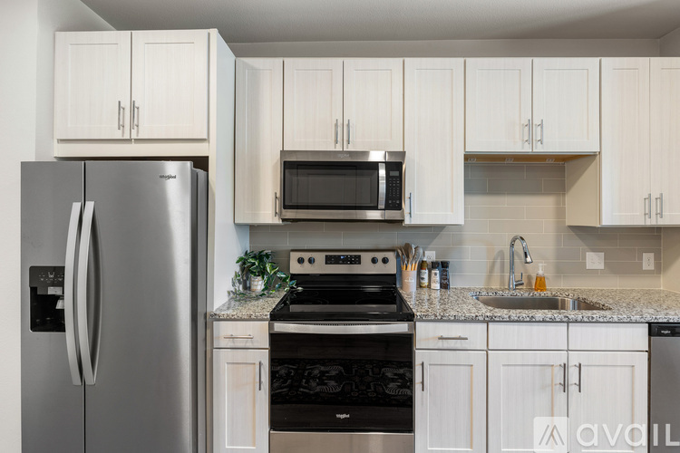 A kitchen with white cabinets and a stainless steel refrigerator.