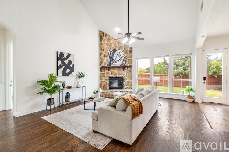 A living room with a stone fireplace and a large couch.