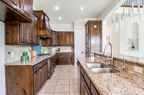 A kitchen with brown cabinets and a granite countertop.