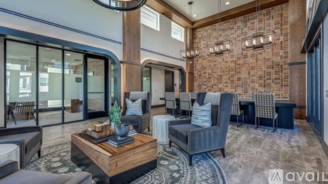 A living room with a brick wall and a coffee table in the center.