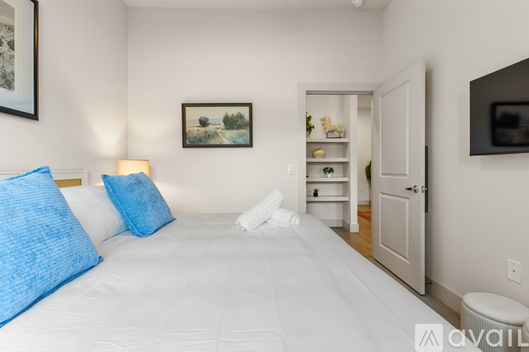 A bedroom with a large bed and a painting on the wall.
