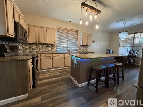 A kitchen with wooden cabinets and a granite countertop.