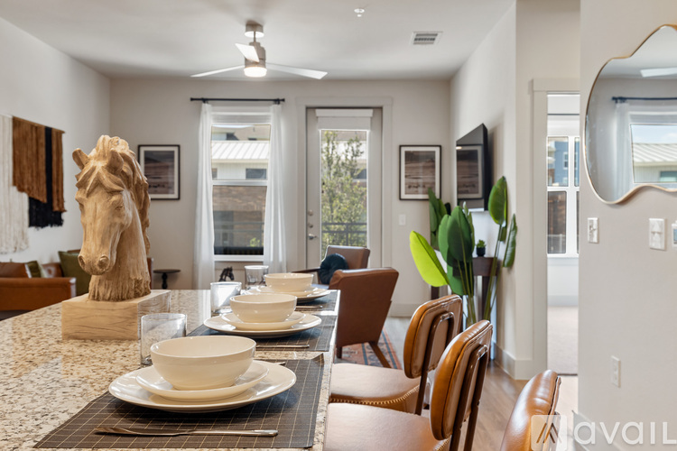 A dining room with a table set for two and a large window.